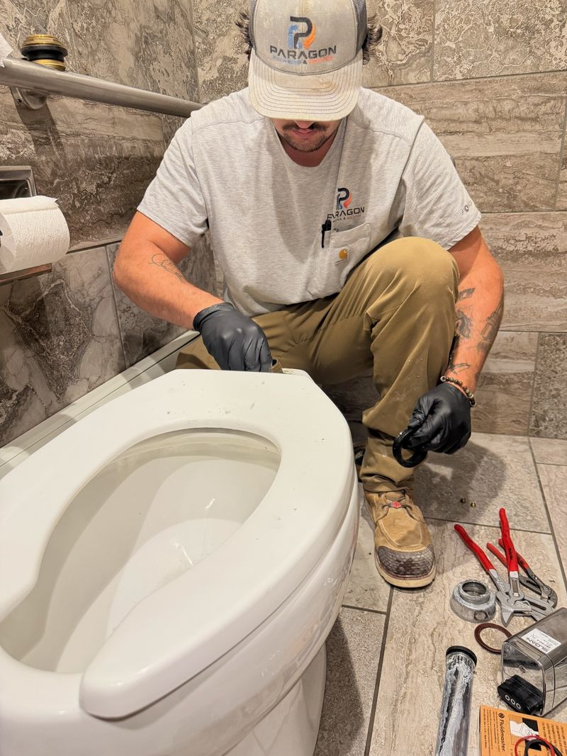 Paragon plumber repairing a commercial toilet flush valve