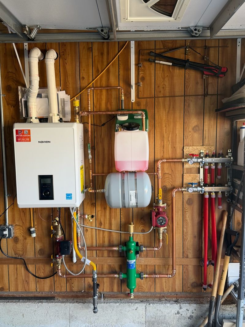 Navien boiler with in-floor heating manifold and copper piping installed in a garage