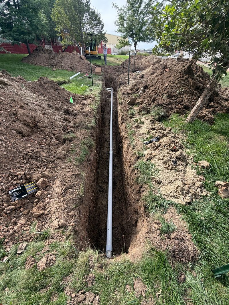 Long trench with new underground pipe being installed